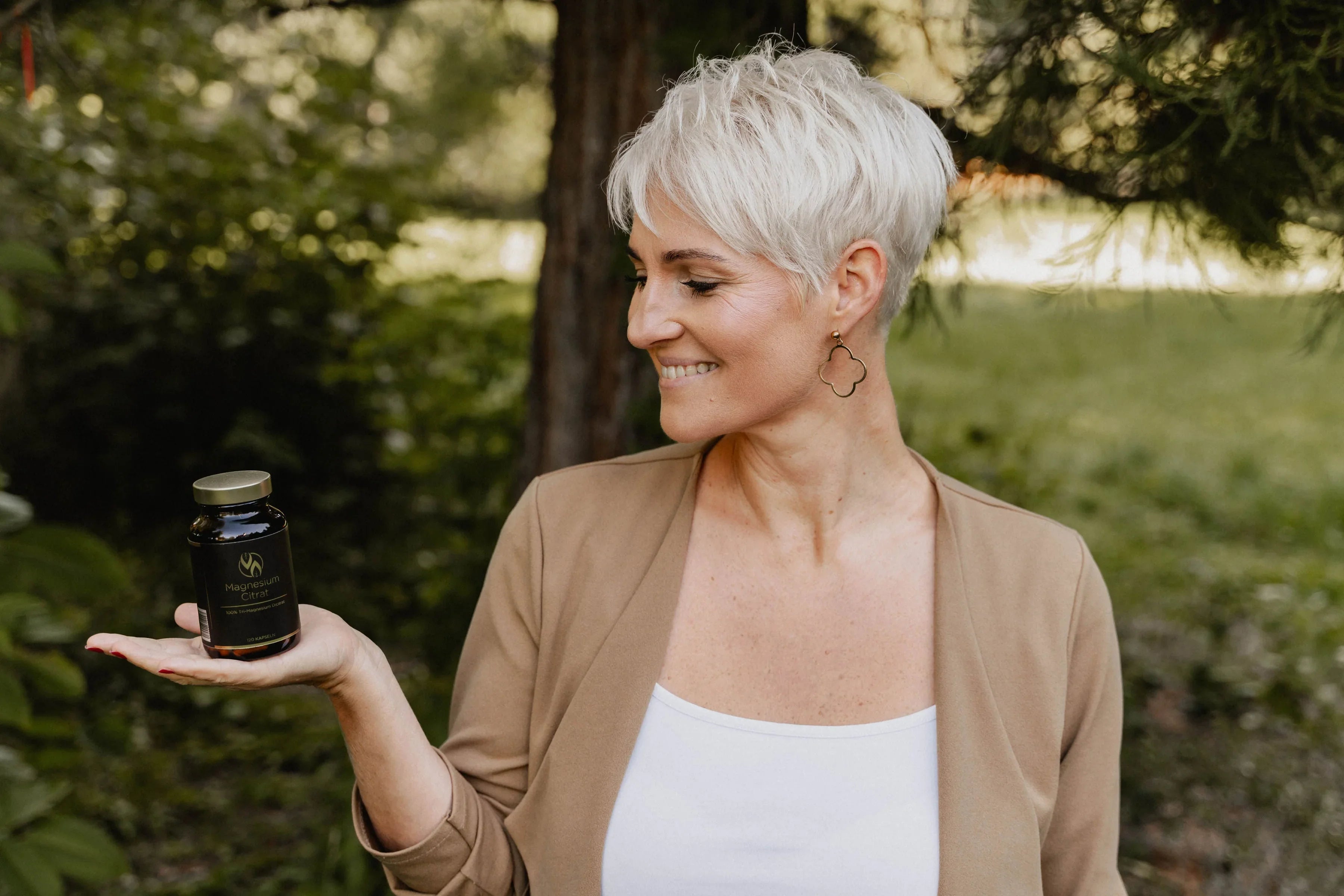 Frau hält Magnesium Citrat Kapseln in der Hand, Nahrungsergänzungsmittel für Gesundheit & Fitness im Freien