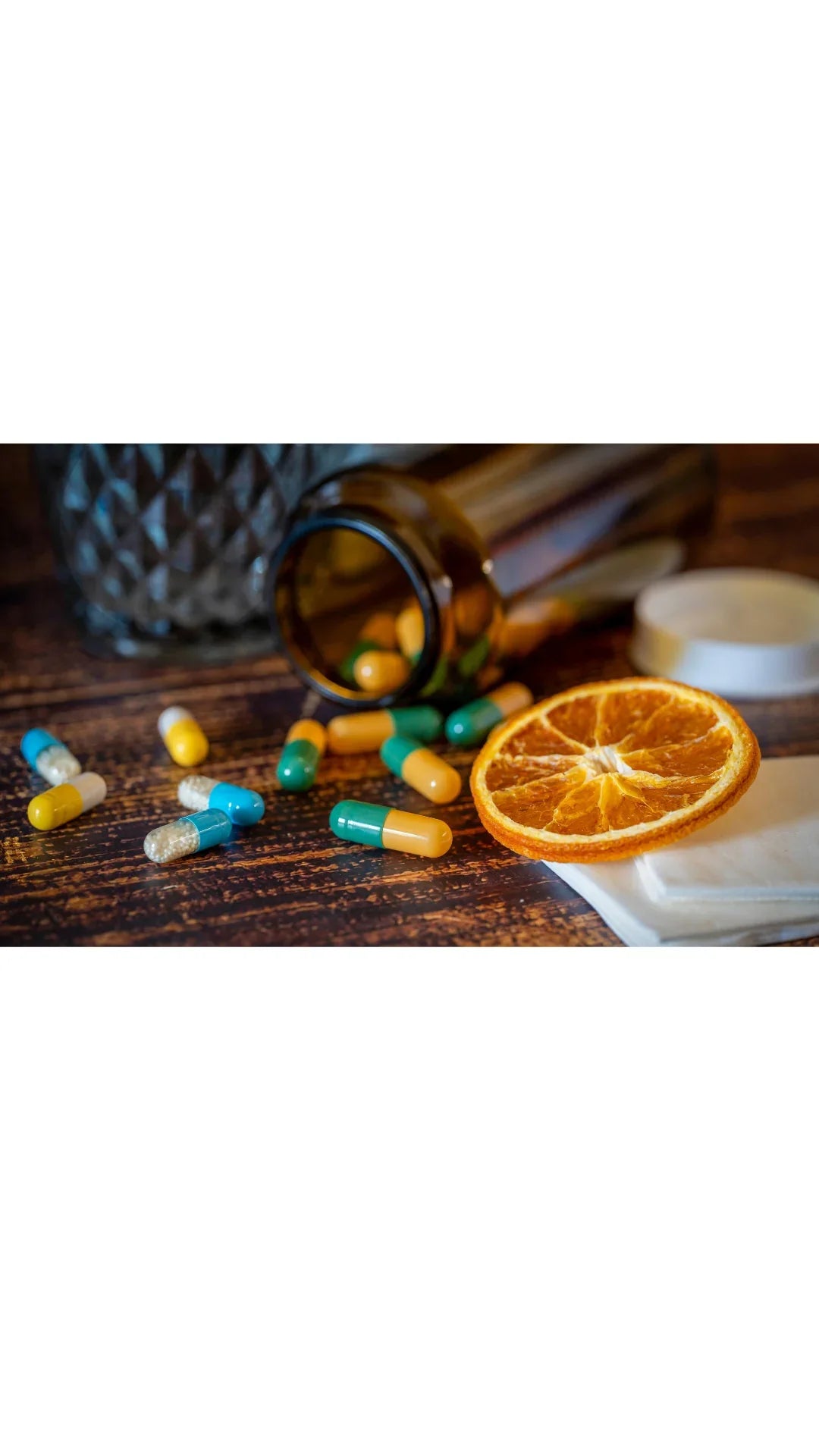 Zinkkapseln auf dem, Tisch und eine getrocknete Orangenscheibe 